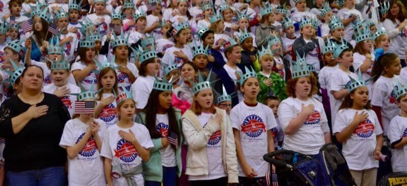 Students with flags at Lady Liberty Assembly