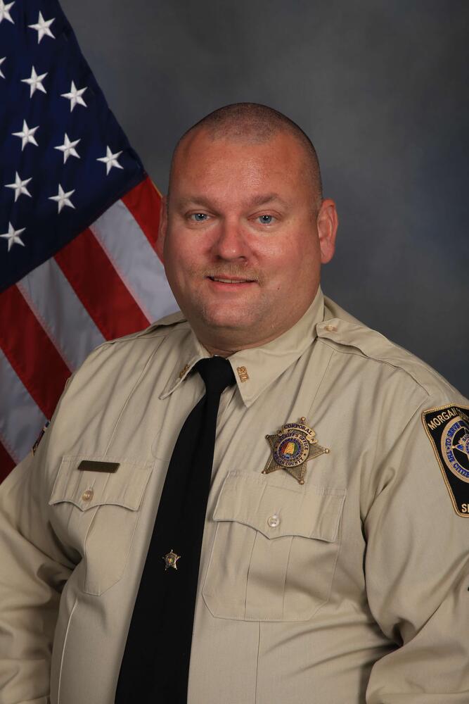 Deputy in uniform by flag