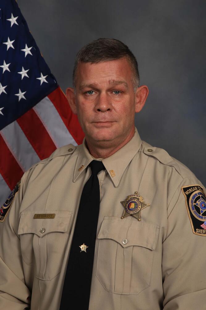 Deputy in uniform by flag