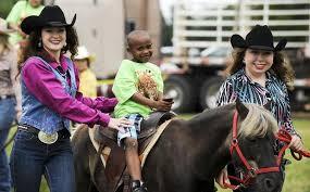 Rodeo queens with student on horse