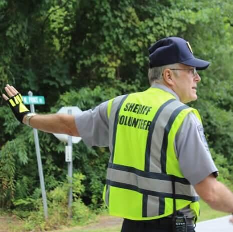 unknown male volunteer directing traffic