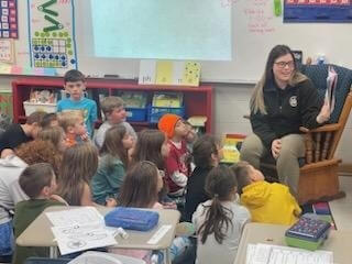 Correction Officer reading to elementary students