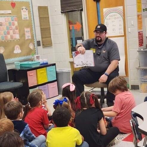 Correction Officer reading to elementary students