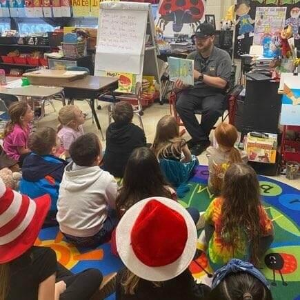 Correction Officer reading to elementary students