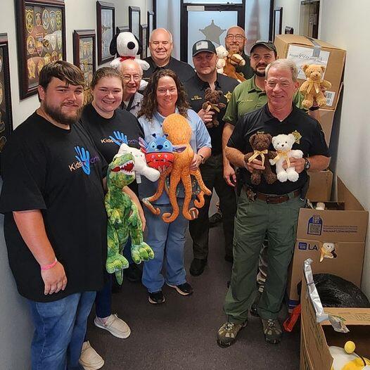 Group standing with pile of stuffed animals